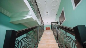 A staircase with ornate railings and a light green wall. - Bethel Suites Hotel (Accra)