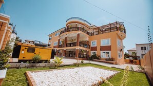 A multi-story residential building with balconies, a paved driveway, and a landscaped garden area. - Bethel Suites Hotel (Accra)