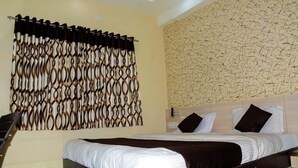 Ein Hotelzimmer mit einem großen Bett, einem Vorhang mit geometrischem Muster und einer strukturierten Wand.