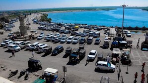 Ein Parkplatz mit verschiedenen Fahrzeugen und einem Denkmal im Hintergrund.