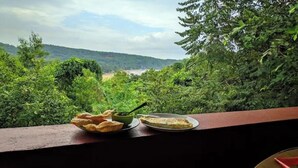 Ein Tisch mit Essen und Soße, mit Blick auf eine üppige grüne Landschaft.