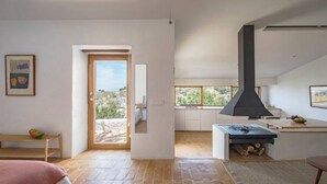 A modern interior with a large window, a fireplace, and a view of the outdoors. - El Castillete – Charm with Sea Views (La Garnatilla)