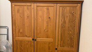 Un armario de madera con tres puertas y un tirador en cada una.