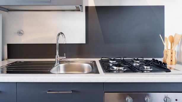 A modern kitchen with a stainless steel sink, a gas stove, and a range hood. - Vanna's House near the center of Florence (Firenze)