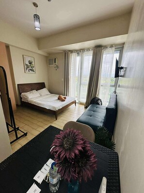 시그니처 스튜디오, 퀸사이즈침대 1개 및 소파베드, 발코니, 시내 전망 | 거실 공간 | 디지털 채널 시청이 가능한 30인치 스마트 TV