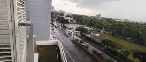 A view from a window overlooking a city street with buildings and a parking lot.