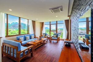 Una habitación amplia con ventanas grandes, muebles de madera y vistas a las montañas.