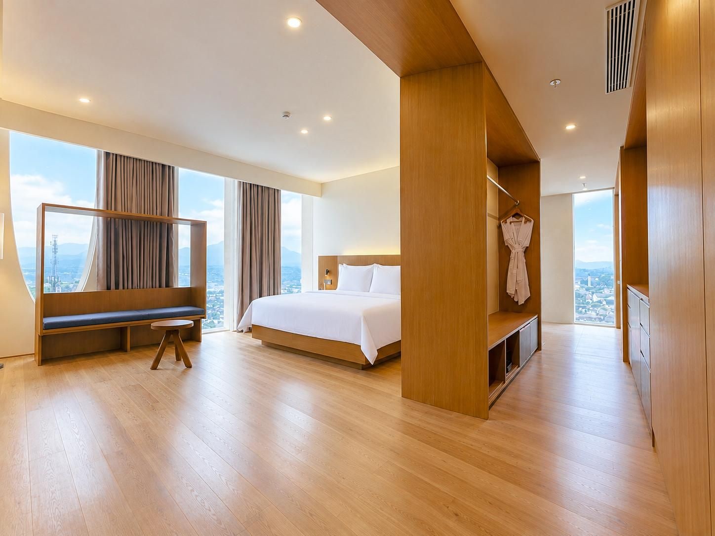 A modern hotel room with a large bed, a seating area with a view, and a walk-in closet.