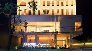 Un hotel moderno con una fachada distintiva que presenta ventanas arqueadas y una entrada central.