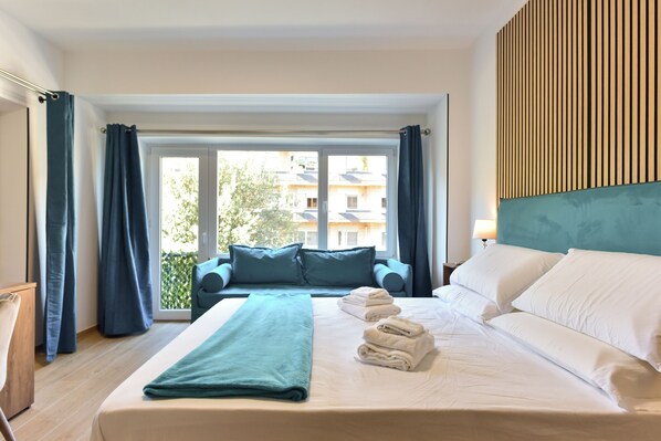 Kolmen hengen deluxe-huone | Tallelokero huoneessa, työpöytä