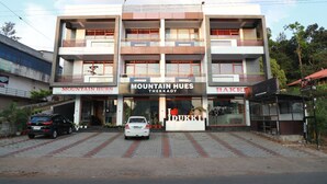 A multi-story building with signage for 'Mountain Hues Thekady' and 'Bakery'. - Hotel Mountain Hues Thekkady (Udumbanchola)