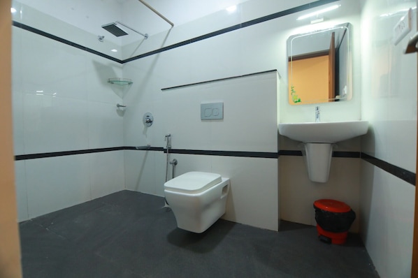 Un baño pequeño y funcional con inodoro, lavamanos y ducha.