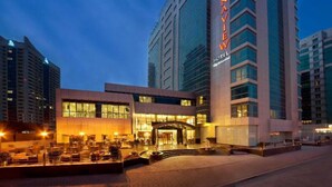 A modern hotel with a prominent 'Marriott' sign, featuring a glass facade and a well-lit entrance. - Belvilla Marina View Suites, Dubai Marina (Dubai)