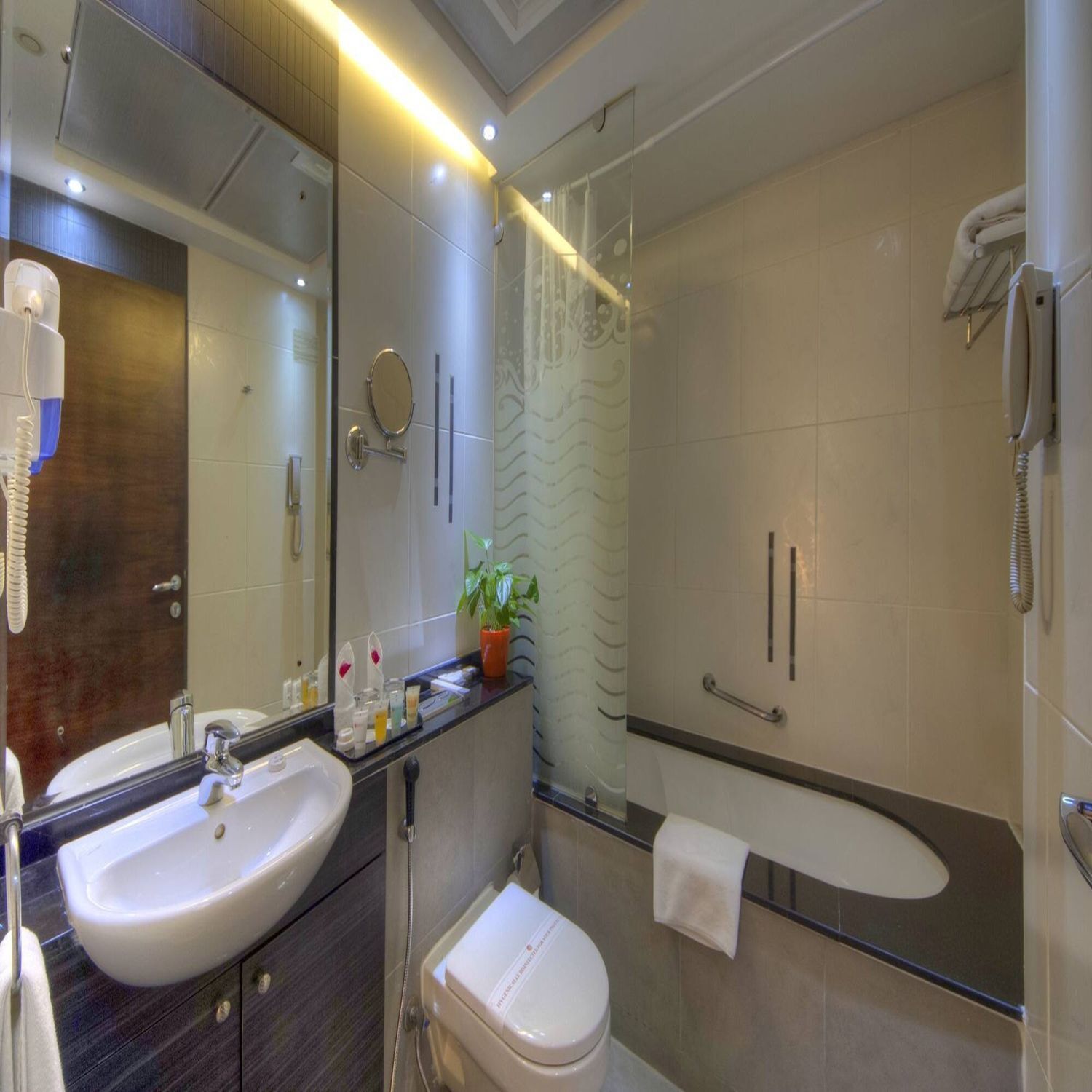 Un baño moderno con lavamanos, inodoro y ducha.