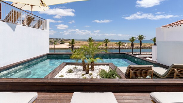 A rooftop pool with lounge chairs and a view of the beach. - Água Hotels Lagos Bay (Lagos)