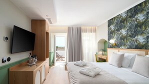 A hotel room with a bed, a TV, a desk with a lamp, and a painting on the wall. - Água Hotels Lagos Bay (Lagos)