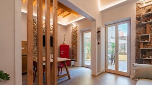 A modern interior with a dining area, a red appliance, and a view through glass doors to an outdoor patio. - Blu's house in Florence (Firenze)