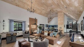 A spacious living area with a wooden ceiling, a sofa set, a coffee table, and a foosball table. - Cedar Hill Lodge | 10 Min to Mt Snow w/Hot Tub (Wardsboro)