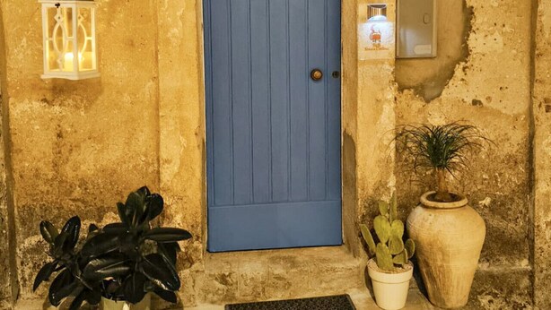 A blue door with a metal handle, a wall-mounted light fixture, a potted plant, and a large vase. - B&B Nonna Cristina - Double Room 1 (Vecchio Abitato)