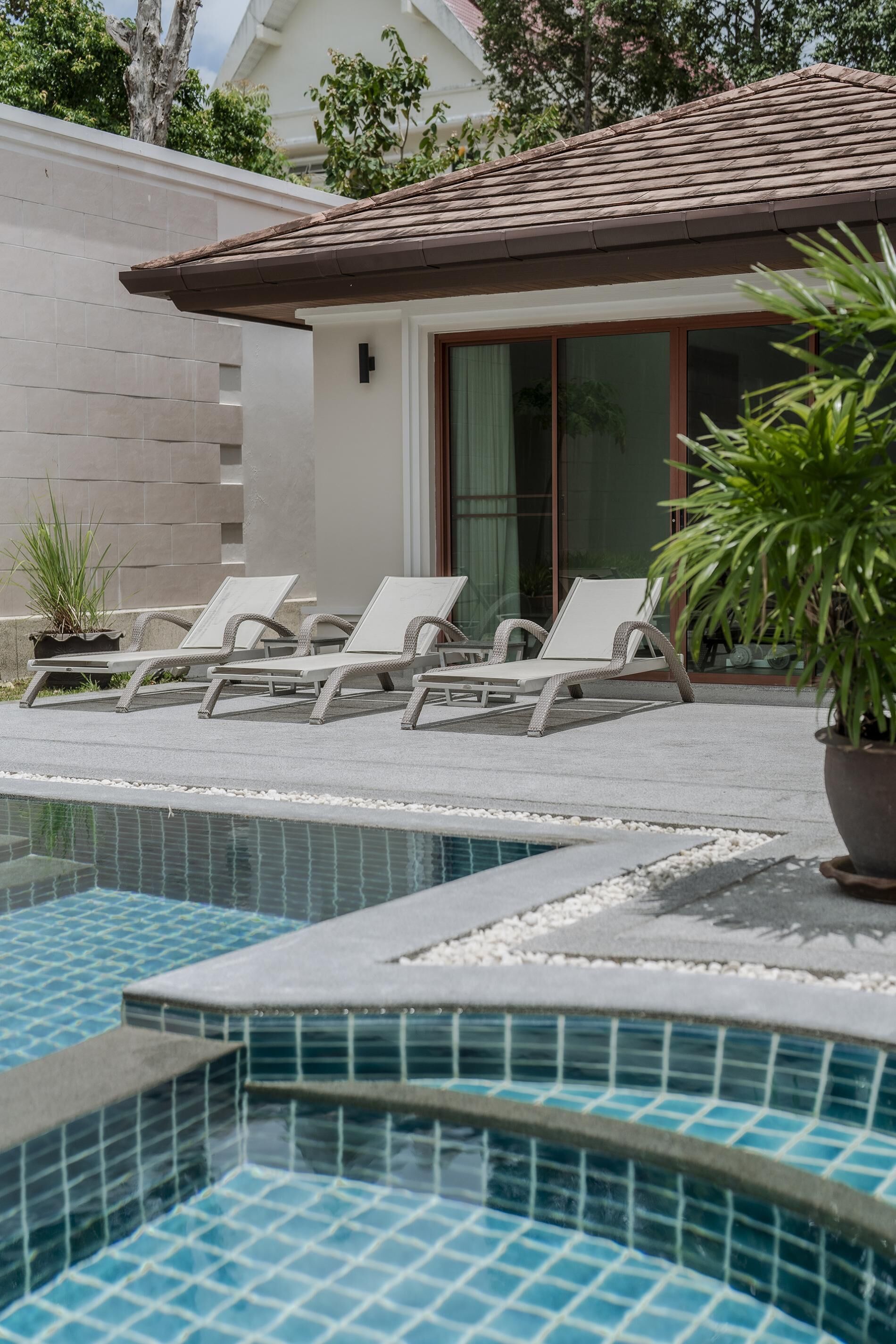 Ein Poolbereich mit Liegestühlen und einem gefliesten Pool.