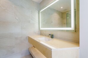 A modern bathroom with a large mirror, a beige vanity, and a shower area. - Pool View Condo 2204, Wyndham Garden Resort (Sa Khu)