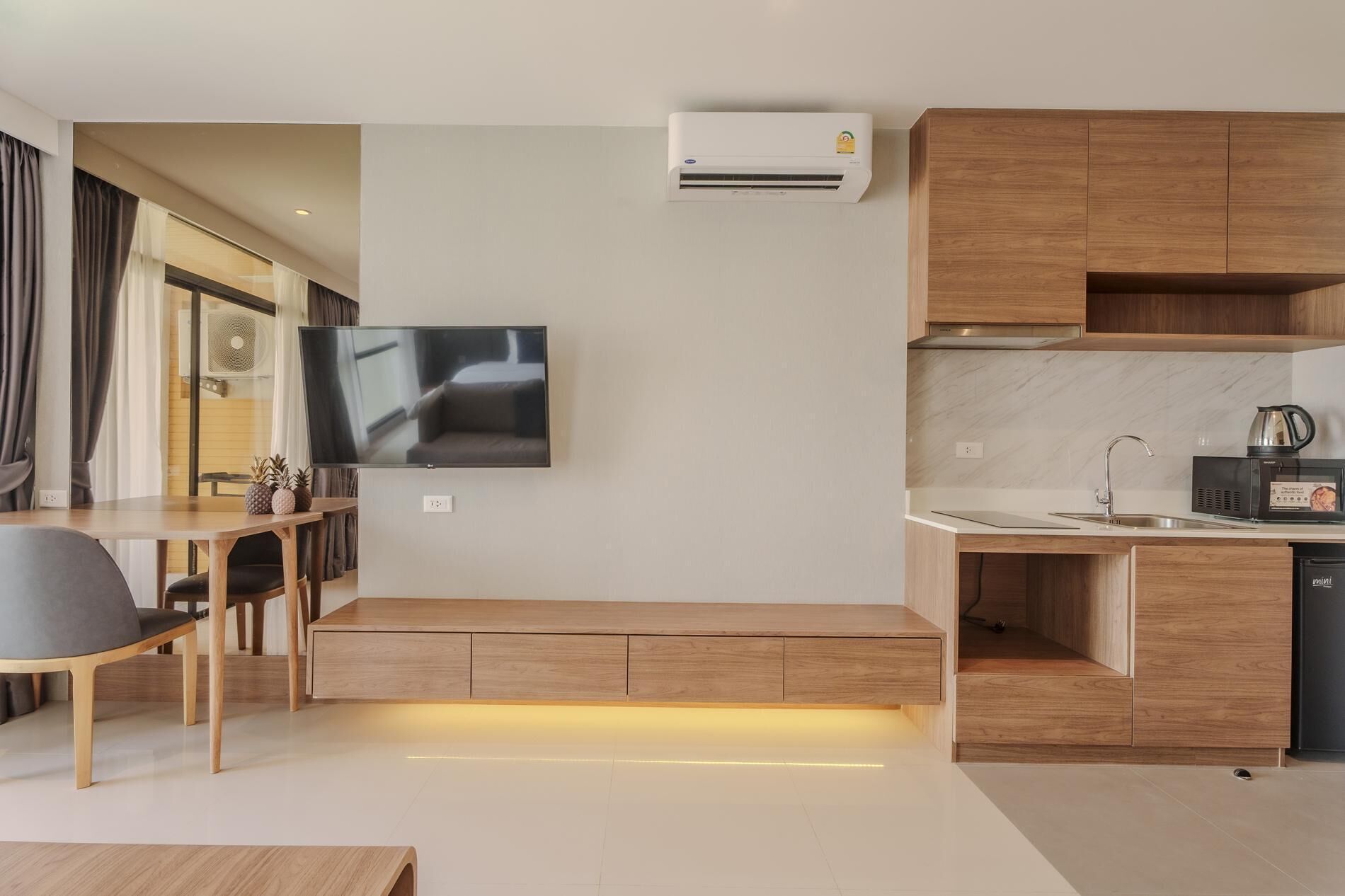 A modern kitchen with wooden cabinets, a built-in oven, and a coffee machine.