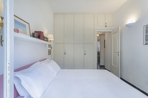 Una camera da letto con un letto, un armadio e una porta che dà su un'altra stanza.