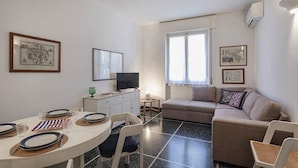 A compact living space with a dining area, a sofa, and a television. - S Margherita Harbour Apartment by Wonderful Italy (Santa Margherita Ligure)