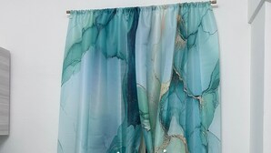 Un baño con piso de mármol, un mueble blanco, una silla verde y una cortina con un estampado abstracto azul y verde.