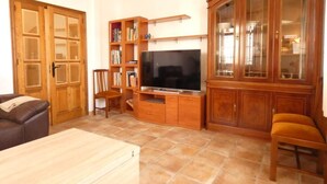 Un salon avec un téléviseur, des meubles en bois et un canapé.
