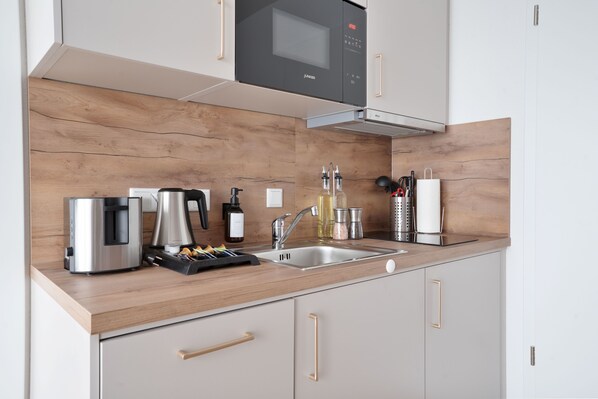 Departamento Deluxe, balcón | Cocina privada | Refrigerador, microondas, parrilla de estufa y utensilios de cocina 