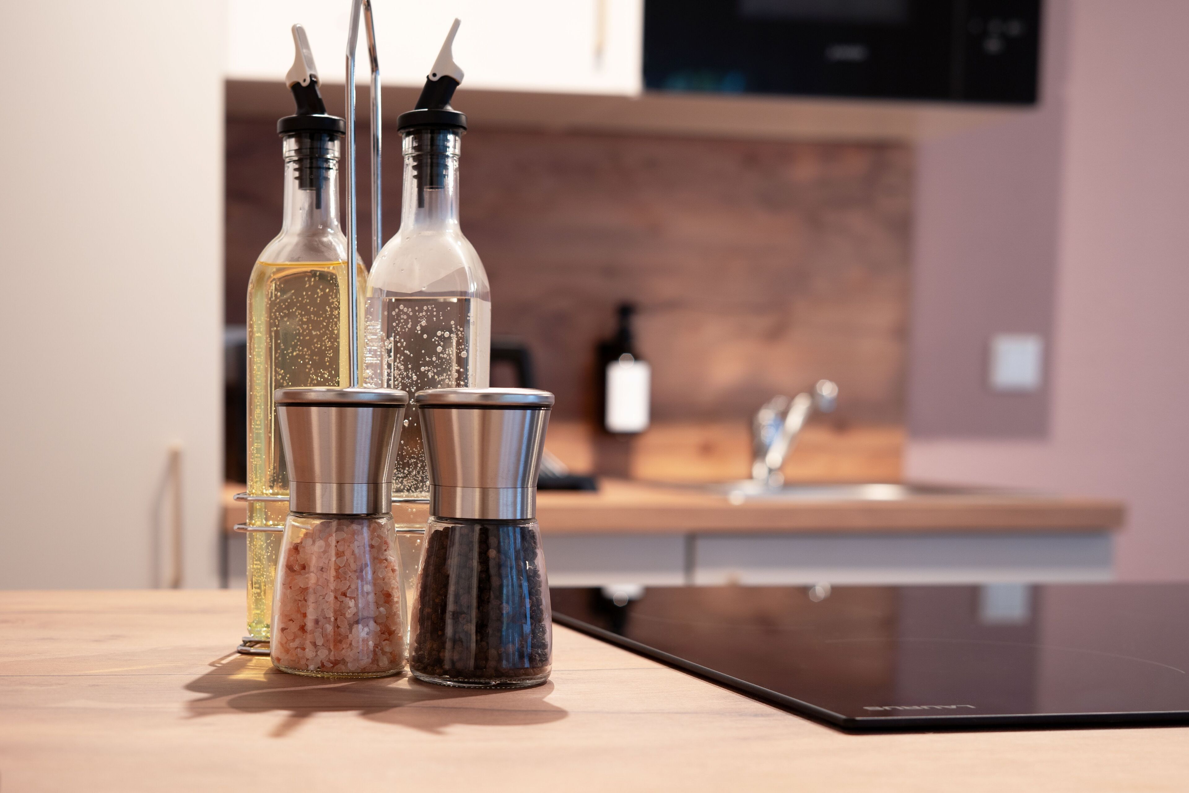 Una encimera de cocina con dos saleros y una botella de aceite.