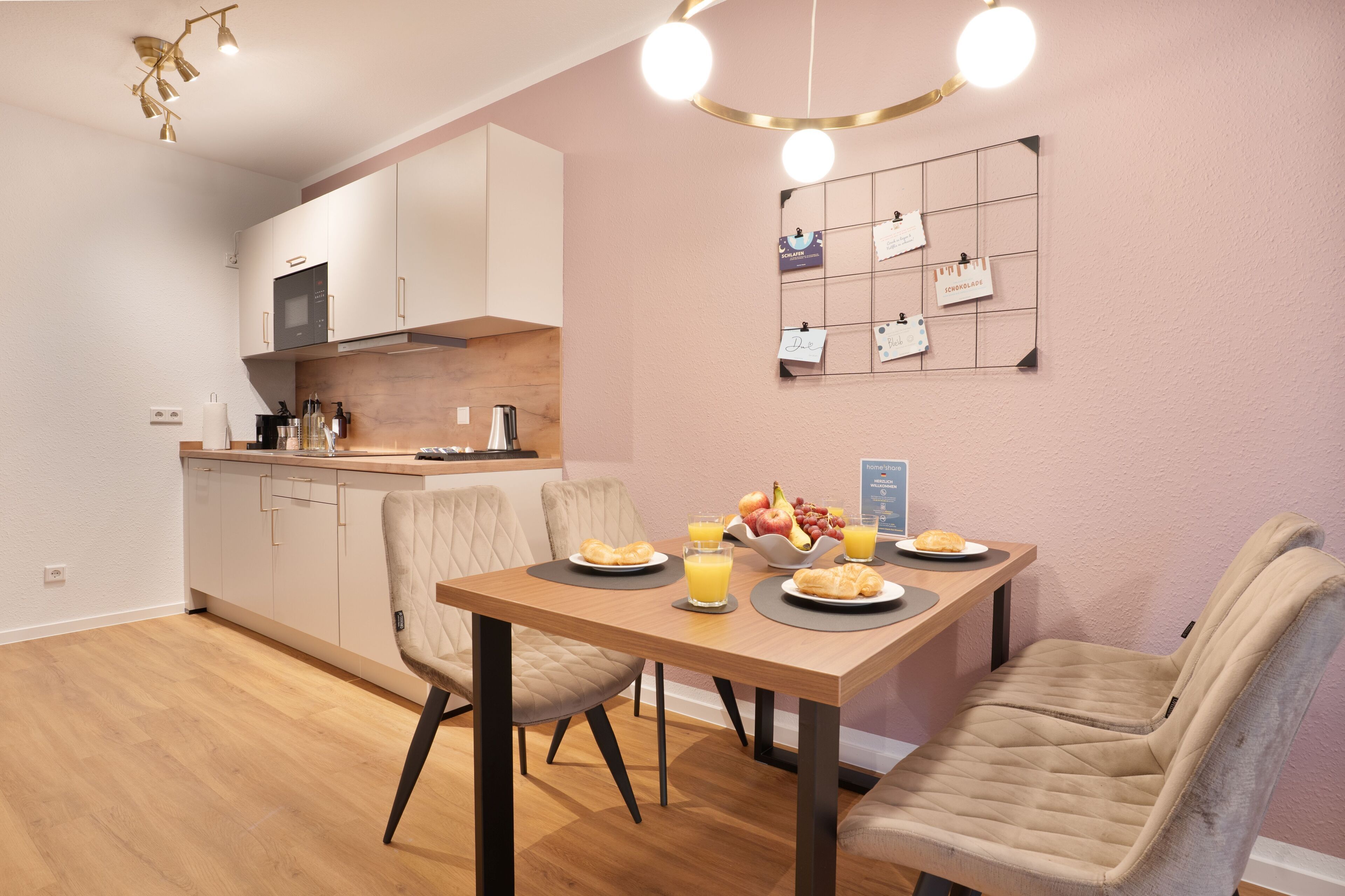 A modern kitchen with white cabinets, a microwave, and a fruit bowl on the counter.