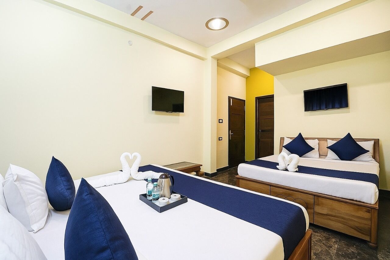 Habitación de hotel con dos camas, televisión y minibar.
