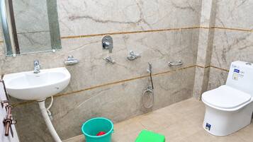 A bathroom with a white sink, a toilet, a shower, and a mirror on the wall.