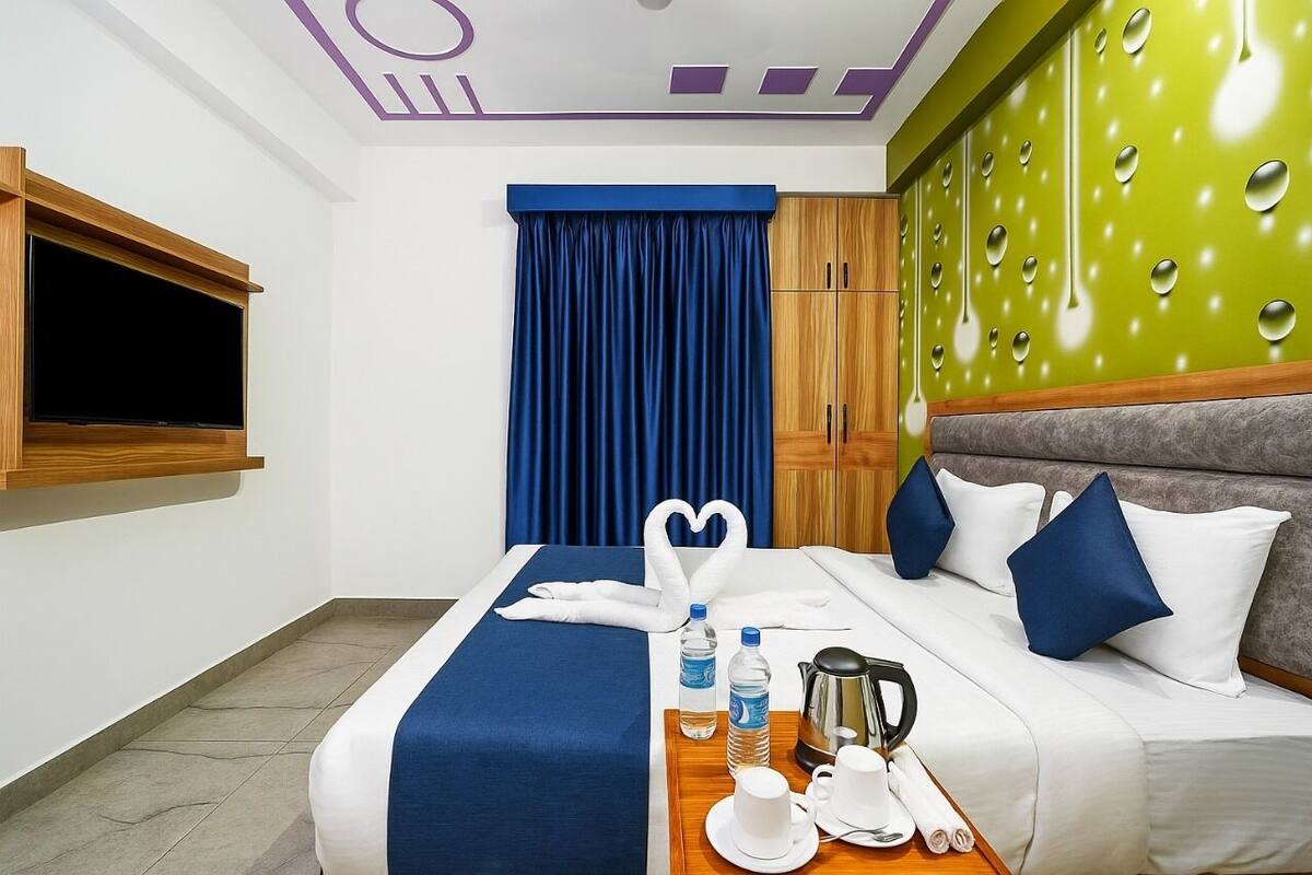 Une chambre d’hôtel équipée d’un lit, d’une télévision, d’une armoire et d’un plateau de petit-déjeuner.