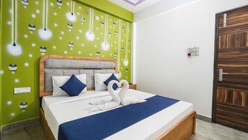 A hotel room with a bed, a green wall, and a wooden door.