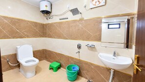 A bathroom with a toilet, sink, and shower. - Minx Hotels Radhika Palace (Ayodhya)