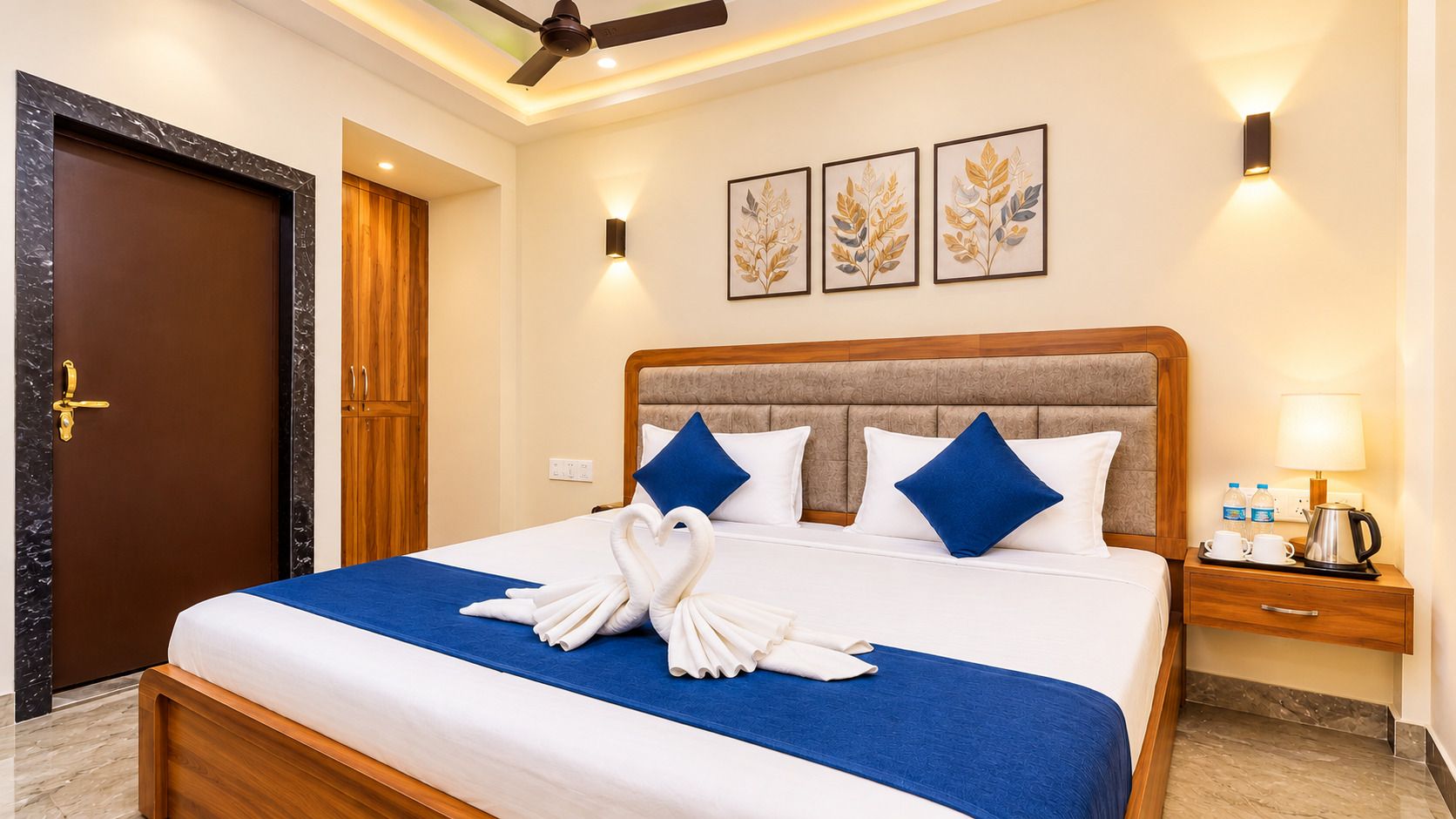 A hotel room with a bed, a nightstand, a lamp, and a door.