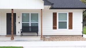A house with a front porch, a bench, and a door marked with the letter 'B'.