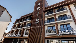 A modern building with a prominent vertical sign reading "ARIS RESTAURANT" and a visible entrance labeled "RECEPCIA". - Aris KOP Kopaonik (Raška)