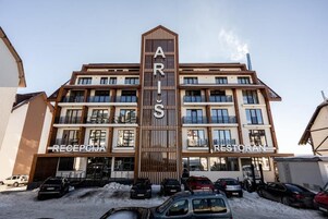 Un hotel de varios pisos con un cartel vertical llamativo que dice "ARIS".