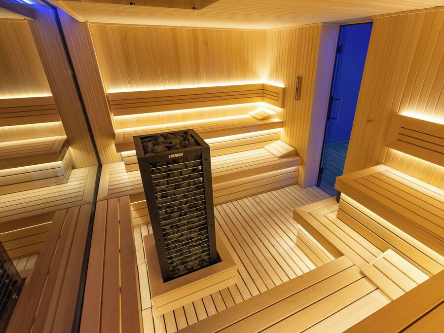 Una sauna con bancos de madera y una unidad de calefacción central.