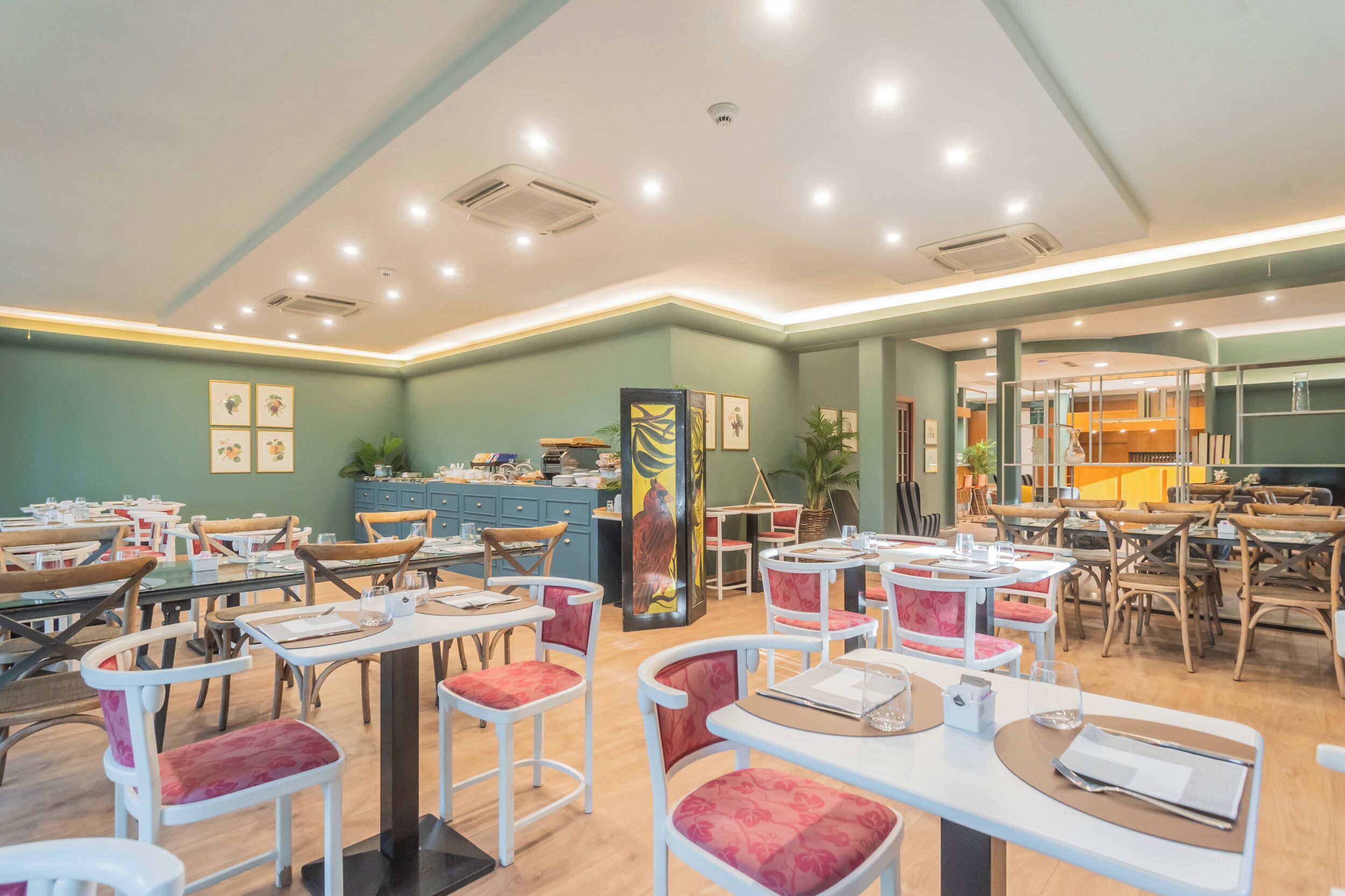 Un restaurante con varias mesas y sillas, una barra con menú y un pilar decorativo grande.