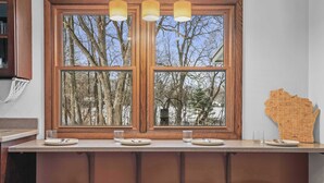 Een keuken met een groot raam, houten krukken en een kaart van Wisconsin aan de muur.