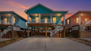 A row of waterfront cabins with a central deck and stairs leading to the upper levels. - Green Casita, Heated Pool, Fire Pit & Outdoor Bar (Port Aransas)
