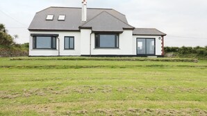 A modern two-story house with a grey roof, white exterior walls, and large windows. - Chynoweth (Newquay)