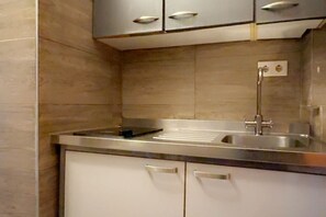 A modern kitchen with stainless steel appliances, a built-in sink, and white cabinetry.
