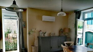 Una cocina acogedora con una mesa de comedor, sillas, un armario y una lámpara colgante.