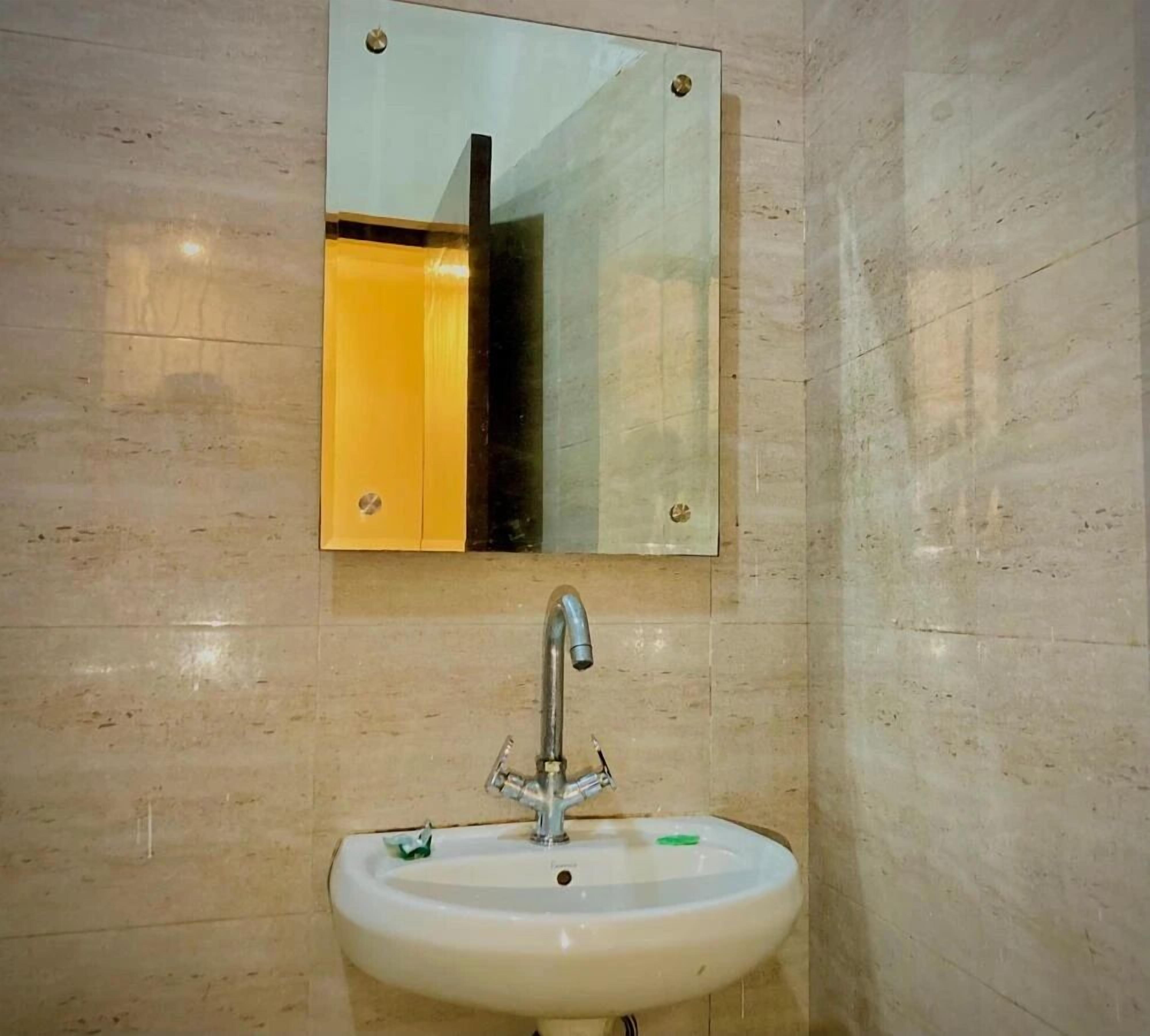 Une salle de bain avec un lavabo, un miroir et des murs carrelés.